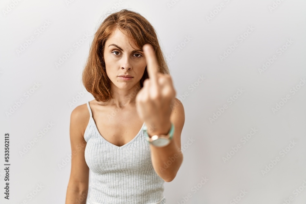 Sticker Beautiful caucasian woman standing over isolated background showing middle finger, impolite and rude fuck off expression