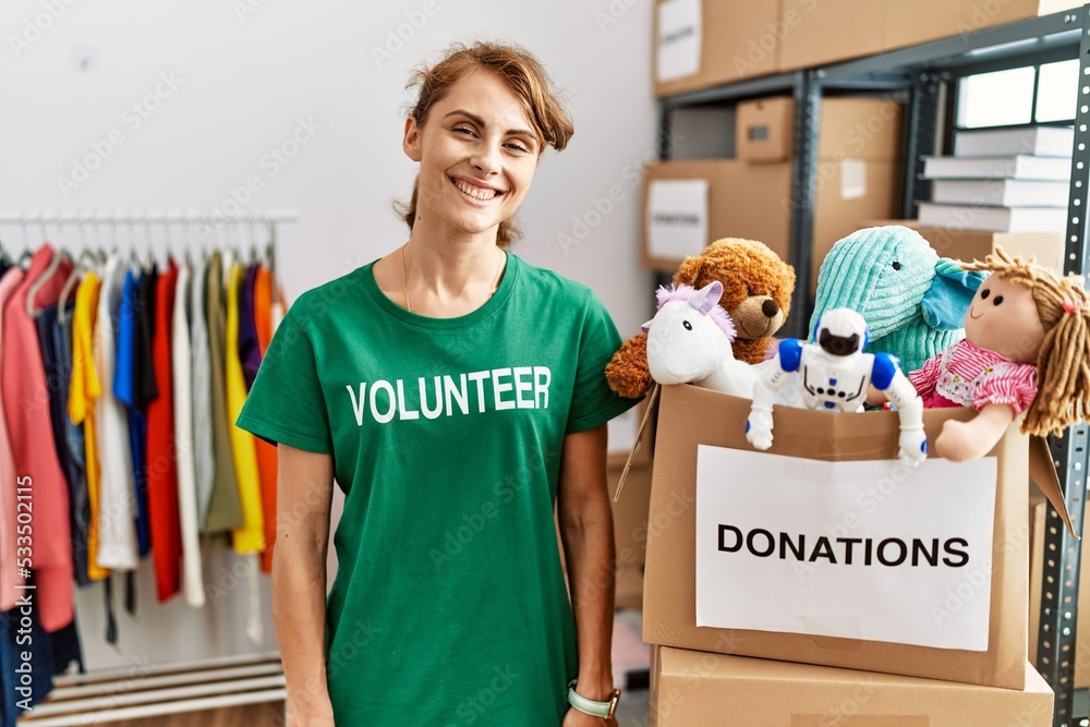 Poster beautiful caucasian woman wearing volunteer t shirt at donations stand with a happy and cool smile o