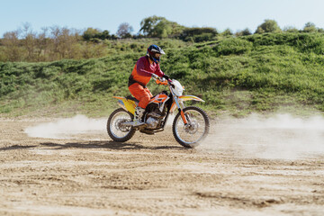 Fototapeta na wymiar Extreme and Adrenaline. Motocross rider in action. Motocross sport. Active lifestyle. Flying dust.