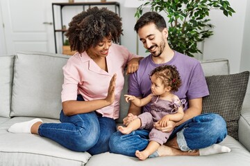 Couple and daughter smiling confident sitting on sofa at home