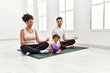 Couple and daughter smiling confident training yoga at sport center