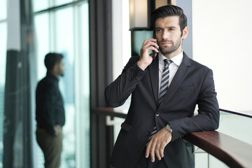 Successful young handsome businessman using phone. Young successful men entrepreneur using mobile phone.