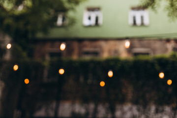 Decorative outdoor string lights at night time, Defocused Background, night city life backdrop, party time with Yellow bokeh balls