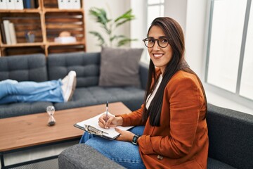Young hispanic woman working as psychology counselor with a happy and cool smile on face. lucky...