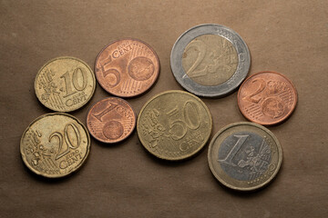 Euro coins are lying on the rough paper background