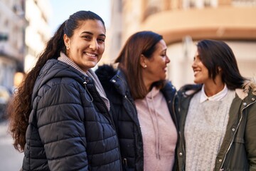 Obraz premium Three woman mother and daughters standing together at street