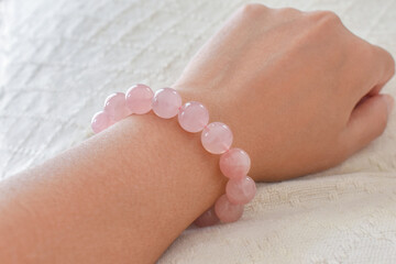 Rose quartz bracelet on a woman wrist. Love magnet, unconditional love, forgiveness and compassion crystal gemstone. Healing and kindness stone.  