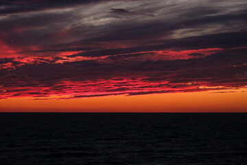 Fototapeta na wymiar Red fire blood sunset sky cloudscape seascape