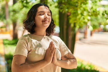 Naklejka premium Young woman smiling confident doing yoga exercise at park