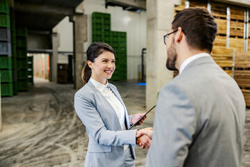 A businesspeople in warehouse shaking hands for agreement and deal in business.