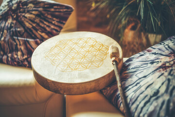 shamanic drum at home on the couch. The flower of life is drawn on the drum.