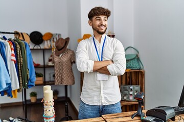 Young arab man shopkeeper smiling confident with arms crossed gesture at clothing store - obrazy, fototapety, plakaty