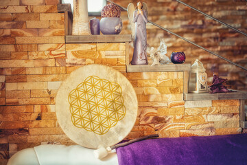 shamanic drum at home on the couch. The flower of life is drawn on the drum.