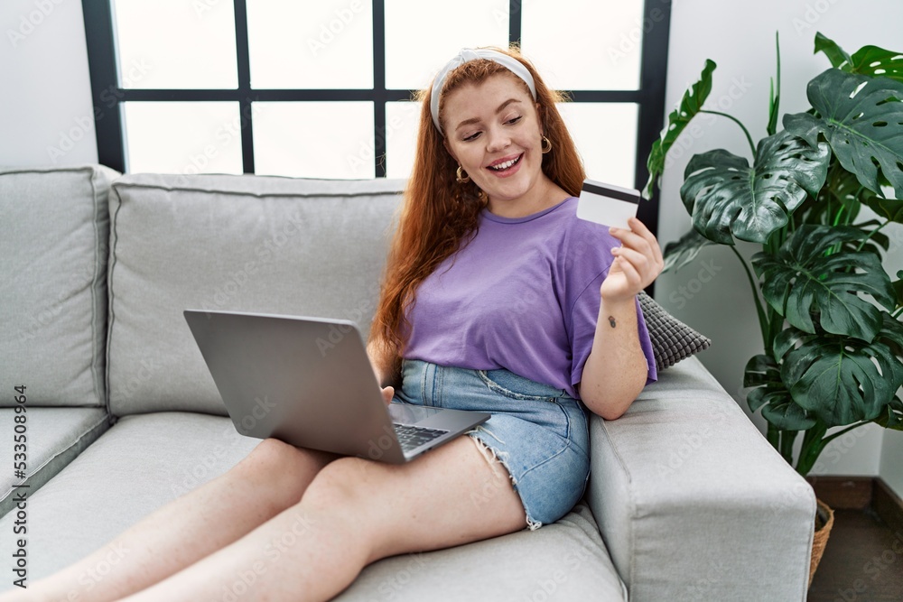 Sticker young redhead woman smiling confident using laptop and credit card at home