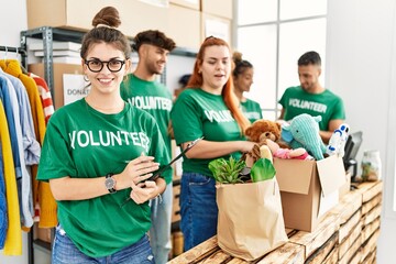 Group of young volunteers smiing happy working at charity center.
