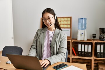 Young chinese call center agent woman smiling happy working at the office.