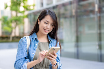 Woman use mobile phone in city at street