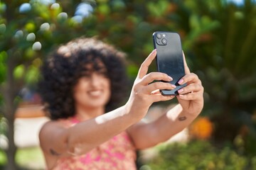 Young middle eastern woman smiling confident making selfie by the smartphone at park