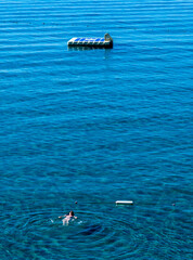 woman swimming to the pontoon 