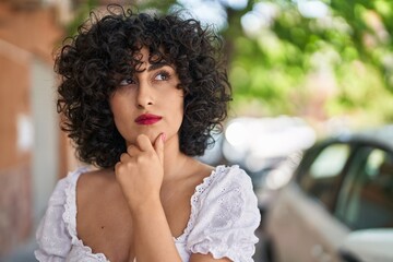 Fototapeta premium Young middle east woman standing with doubt expression at street