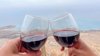 Cheers. Couple enjoying a glass of wine in a beautiful seabackground.