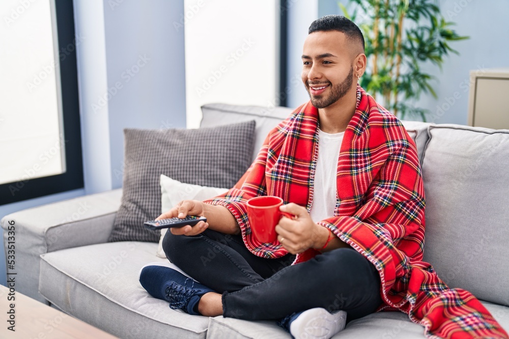 Canvas Prints African american man drinking coffee watching tv at home