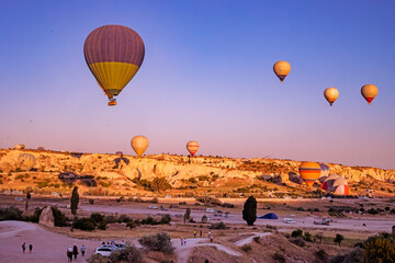 flight of hot air balloons in the morning blue sky over the goreme valley in Cappadocia, horizontal