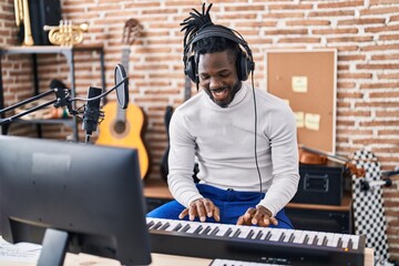 African american woman musician playing piano keyboard at music studio