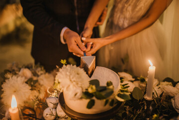 Newlyweds cutting wedding cake. The sweetest tradition of a wedding.