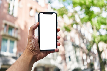 Man holding smartphone showing white blank screen at street