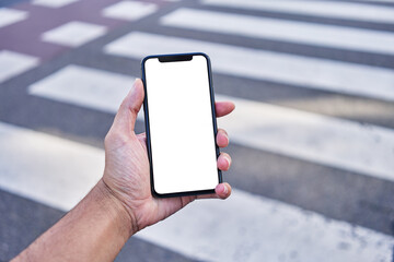 Man holding smartphone showing white blank screen at street