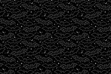 Silhouettes of cartoon bats on a black background. Seamless pattern