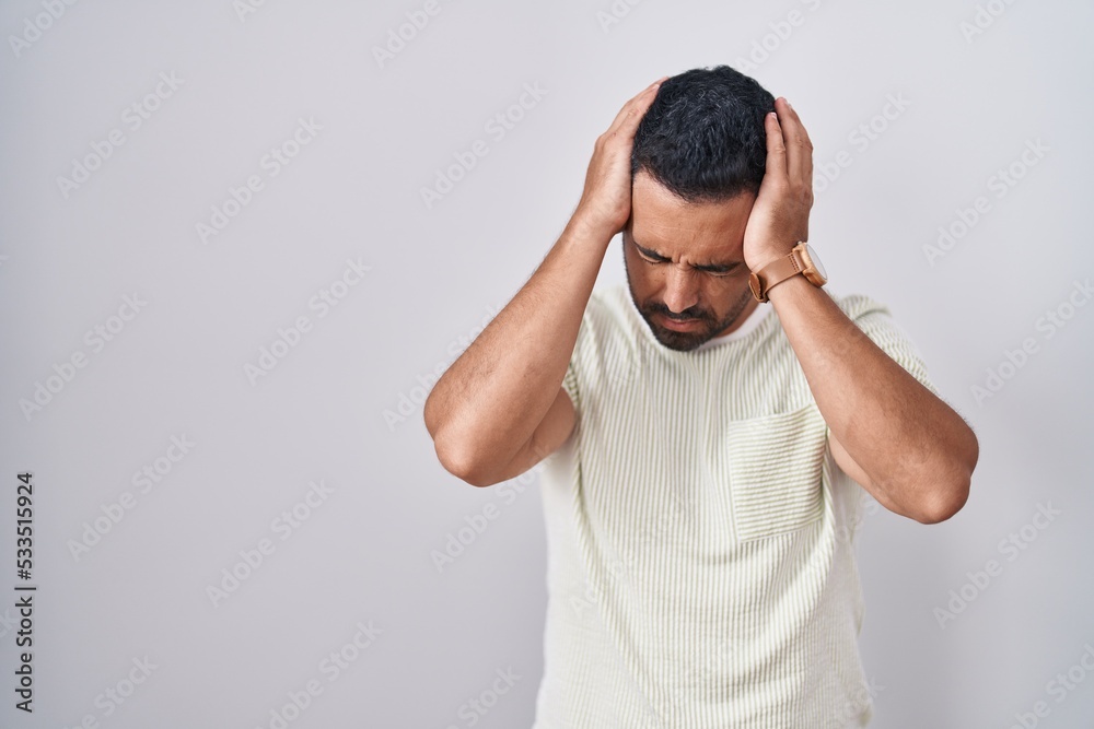 Sticker Hispanic man with beard standing over isolated background suffering from headache desperate and stressed because pain and migraine. hands on head.