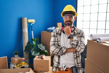 Young hispanic man with beard working at home renovation thinking worried about a question,...