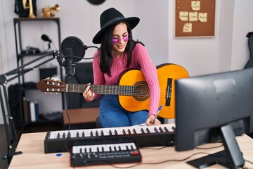 Fototapeta na wymiar Young caucasian woman musician composing song playing classical guitar at music studio