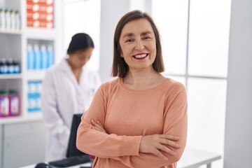 Two women pharmacist and customer smiling confident at pharmacy