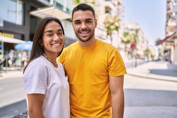 Young latin couple smiling happy and hugging standing at the city.