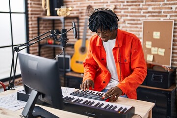 African american man musician playing piano keyboard at music studio
