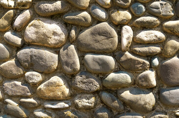 The texture of the wall of brown stone masonry.