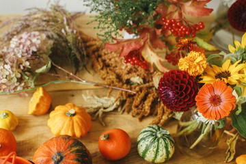 Autumn flowers, pumpkins, berries on rustic wooden table. Autumn still life. Harvesting at farm. Hello Fall