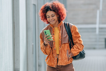afro american latin girl walking with mobile phone in the city