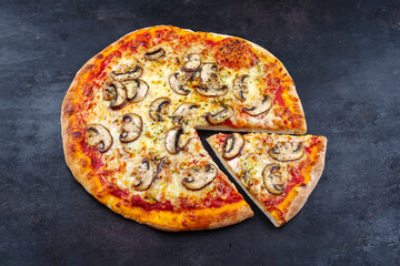 Traditional Italian pizza funghi with mushrooms and mozzarella served as close-up on an old rustic board with text free space