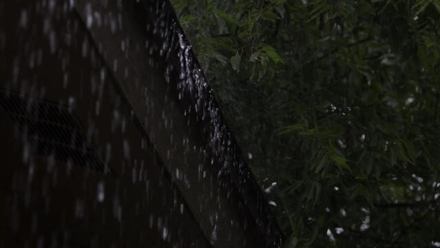 Heavy rain pours from house roof