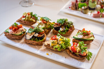 appetizers at the wedding reception. gourmet bruschetta with pate, zucchini, tomato, cucumber and herbs.
