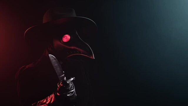 Plague doctor with sharp knife on black smoke background. Creepy raven mask, halloween, historical terrible protection costume, mystical fantasy. Epidemic, death concept