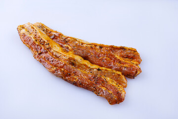Traditional rohe würzig marinierte Schweinebauch Scheiben zubereitet für eine Sommer Grillparty und angeboten als close-up auf einem grauen Board mit Textfreiraum