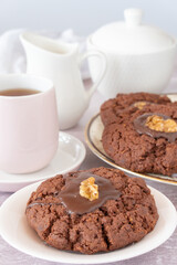 Close Up of Plate of New Zealand Chocolate Afghan Cookies with Cup of Tea, milk jug and sugar Vertical
