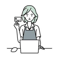 デスクで座ってPCを使いながらクレジットカードを手に持っている店員の女性