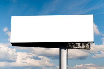 Mock up - blank wide horizontal white billboard or large advertising display against blue sky with...