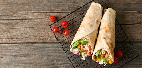 Tasty doner kebabs and tomatoes on wooden background with space for text, top view